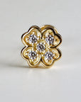 A gold clover-shaped stud earring with five clear, round gemstones. The earring has a detailed, floral design and is set against a white background. The earring is a piece of jewelry.