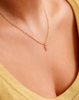 A gold chain necklace with a small letter &