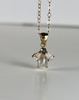 14k solid gold necklace featuring a rose cut salt and pepper diamond flanked by two pear-shaped moissanites in a cluster design, displayed on a white background.