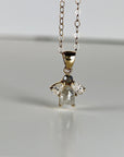 14k solid gold necklace featuring a rose cut salt and pepper diamond flanked by two pear-shaped moissanites in a cluster design, displayed on a white background.