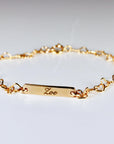Custom gold filled bar bracelet with a child’s name engraved, shown on a white background. Dainty and personalized baby jewelry.