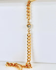 Gold filled curb chain bracelet with a faceted heart-shaped cubic zirconia charm at the center, shown on a white background.