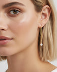 Model wearing pearl threader earrings with delicate gold chain and pearl drop, elegant minimalist bridal jewelry