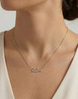 Woman wearing a personalized 14K gold diamond name necklace.
