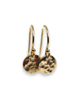 A pair of gold hammered disc earrings with a simple hook closure.