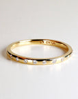 A thin gold band with a row of small diamonds set around the edge.
