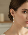 Gold filled pearl drop earrings worn on ear with zircon stud detail
