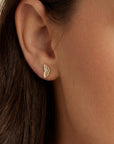 Close-up of a person wearing a small, solid gold butterfly wing stud in a lobe piercing. The minimalist gold jewelry shines against the skin, showcasing its delicate size and nature-themed design for everyday wear.