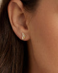 Close-up of a person wearing a small, solid gold butterfly wing stud in a lobe piercing. The minimalist gold jewelry shines against the skin, showcasing its delicate size and nature-themed design for everyday wear.