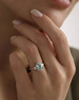 Prong set oval aquamarine engagement ring on model hand in 14k gold