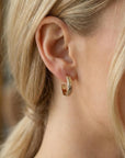 Model wearing small gold filled hoop earrings with floral pattern, chunky open hoop design, minimalist jewelry