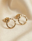 10mm hammered circle stud earrings in gold filled displayed on neutral flat lay background, minimalist handmade earrings