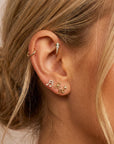 Model wearing dainty bow flat back earring in 14k solid gold, tiny ribbon stud in tragus piercing, internally threaded labret jewelry, minimalist cartilage earring