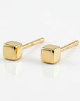 A pair of gold square stud earrings. The earrings are small and simple, with a minimalist design.