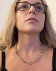 Prehnite silk hand knotted necklace worn at the neckline showing 20 inch length and figure eight charm holder clasp at the front.