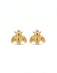 A pair of gold bee stud earrings with smooth, rounded bodies and wings are centered on a plain white background.