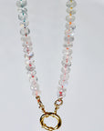 Hand knotted moonstone rondelle necklace on rainbow silk with gold filled figure eight clasp laid flat on white background.