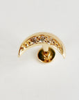 A gold crescent moon flat back piercing with cubic zirconia stones viewed from the back.