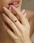 Close-up of a person wearing the gold multi-gemstone cluster ring on their ring finger, with light pink polished fingernails.