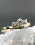 The gold chevron diamond ring displayed upright on top of a rough crystal formation.