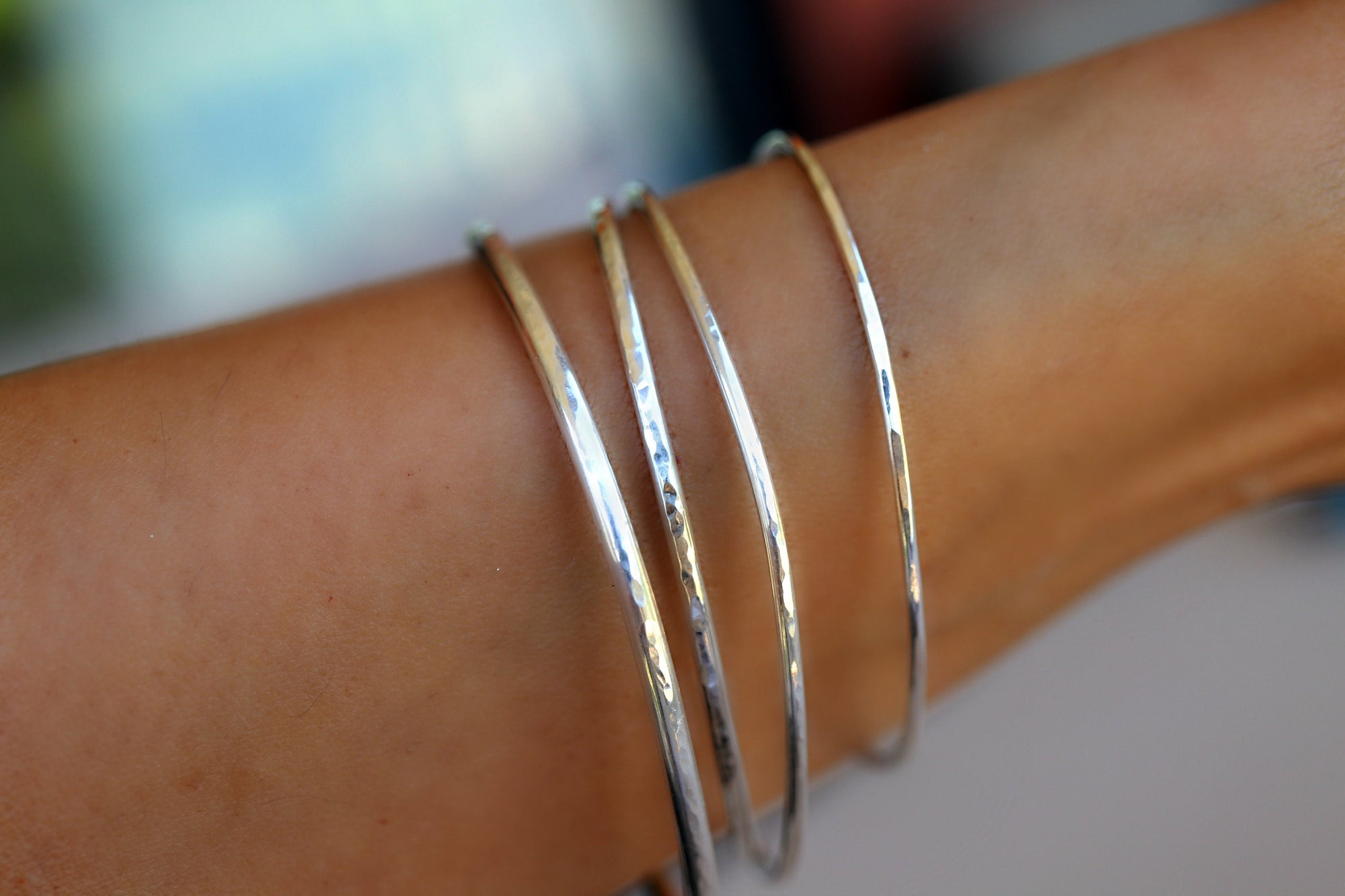 Hammered Silver Bracelets on the wrist.