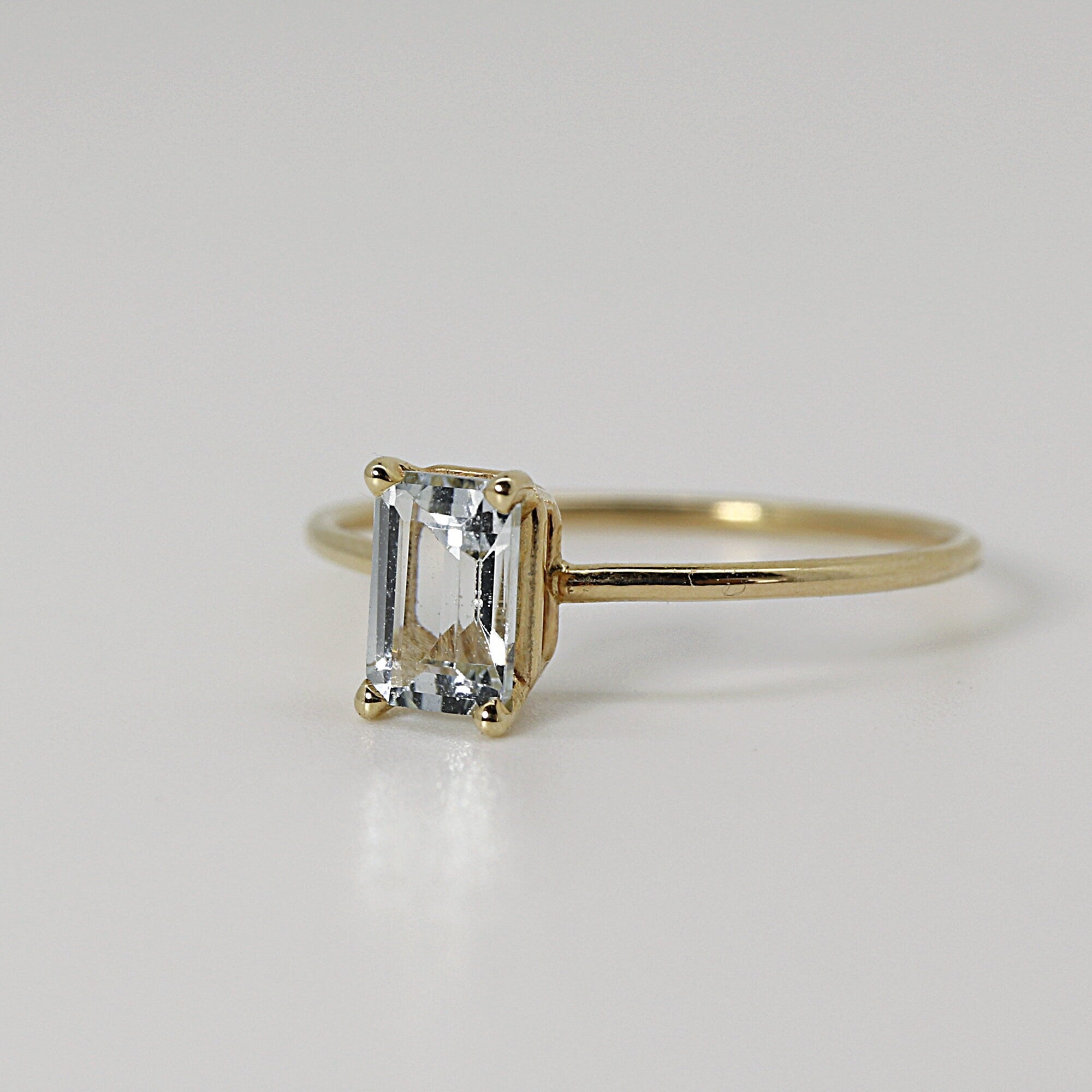 A clear emerald cut gemstone ring in 14k Gold
