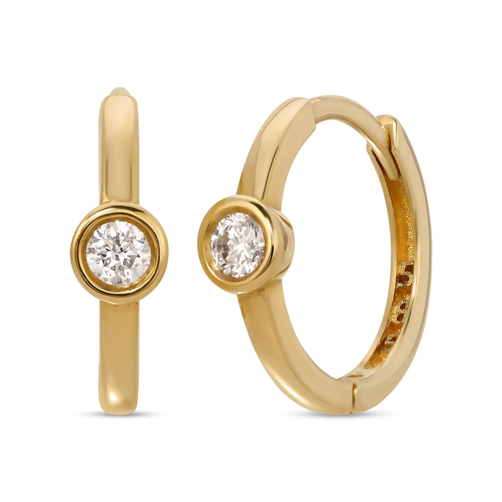 A pair of gold hoop earrings with a single clear diamond in each hoop.