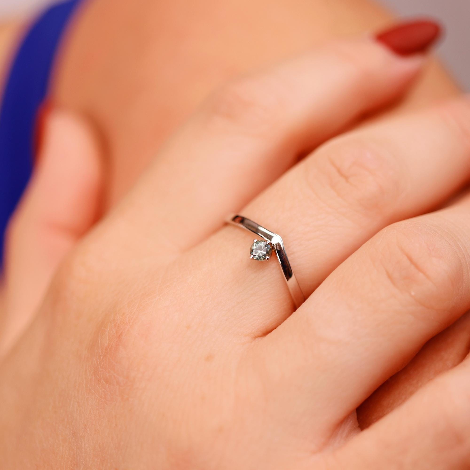A gold ring with a single montana sapphire set in a v-shaped band.