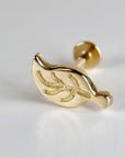 Gold leaf-shaped body jewelry with a textured surface. The jewelry is designed for a piercing and has a post with a small ball on the end.