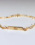 Custom gold filled bar bracelet with a child’s name engraved, shown on a white background. Dainty and personalized baby jewelry.