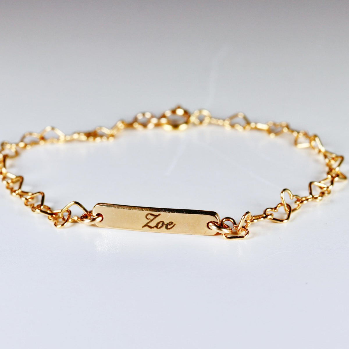 Custom gold filled bar bracelet with a child’s name engraved, shown on a white background. Dainty and personalized baby jewelry.