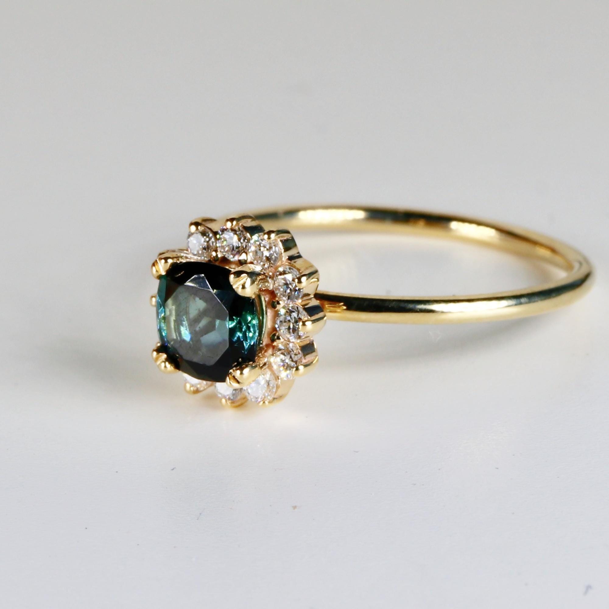 Cushion cut indicolite tourmaline halo engagement ring set in 10k yellow gold with lab-grown diamonds, displayed on a clean white background.