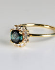Cushion cut indicolite tourmaline halo engagement ring set in 10k yellow gold with lab-grown diamonds, displayed on a clean white background.