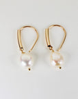 Gold filled dangle earrings featuring large natural baroque pearls with organic shapes, displayed on a white background.