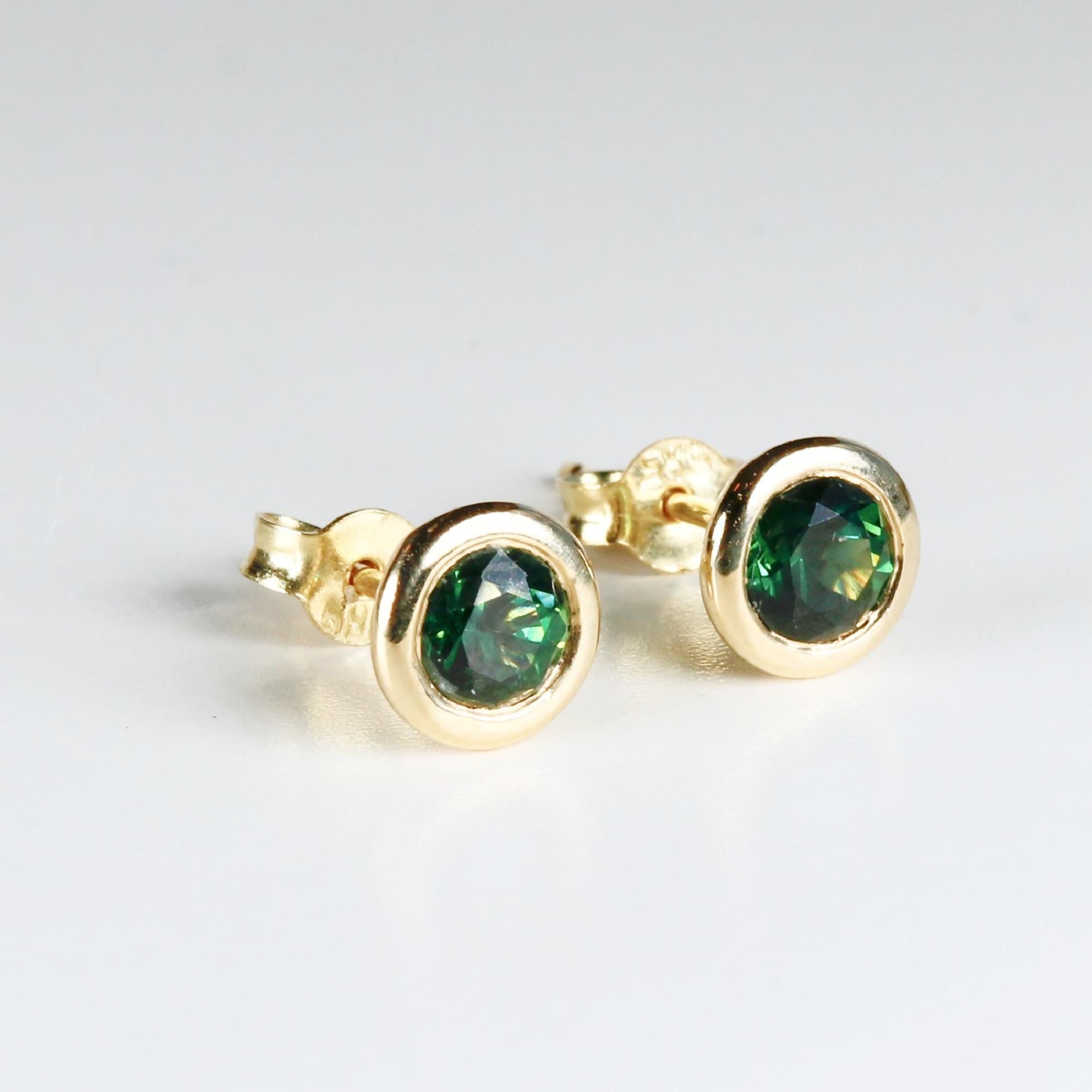 Pair of green sapphire martini bezel stud earrings in 14k solid gold, displayed on a clean white background.
