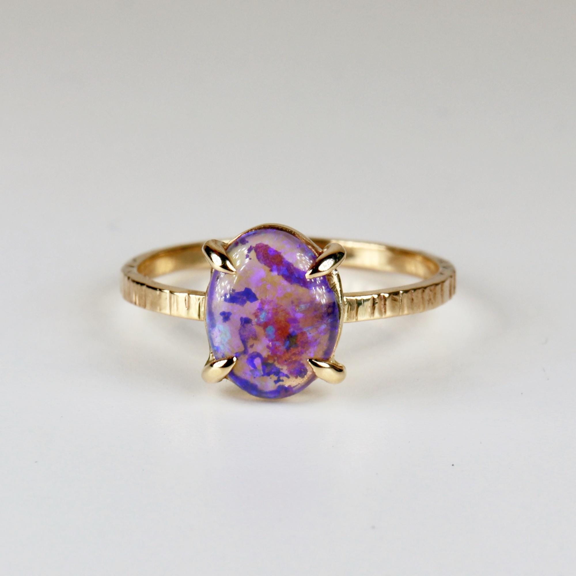 14k solid gold ring featuring a natural purple Australian opal, displayed on a white background with vibrant flashes of color