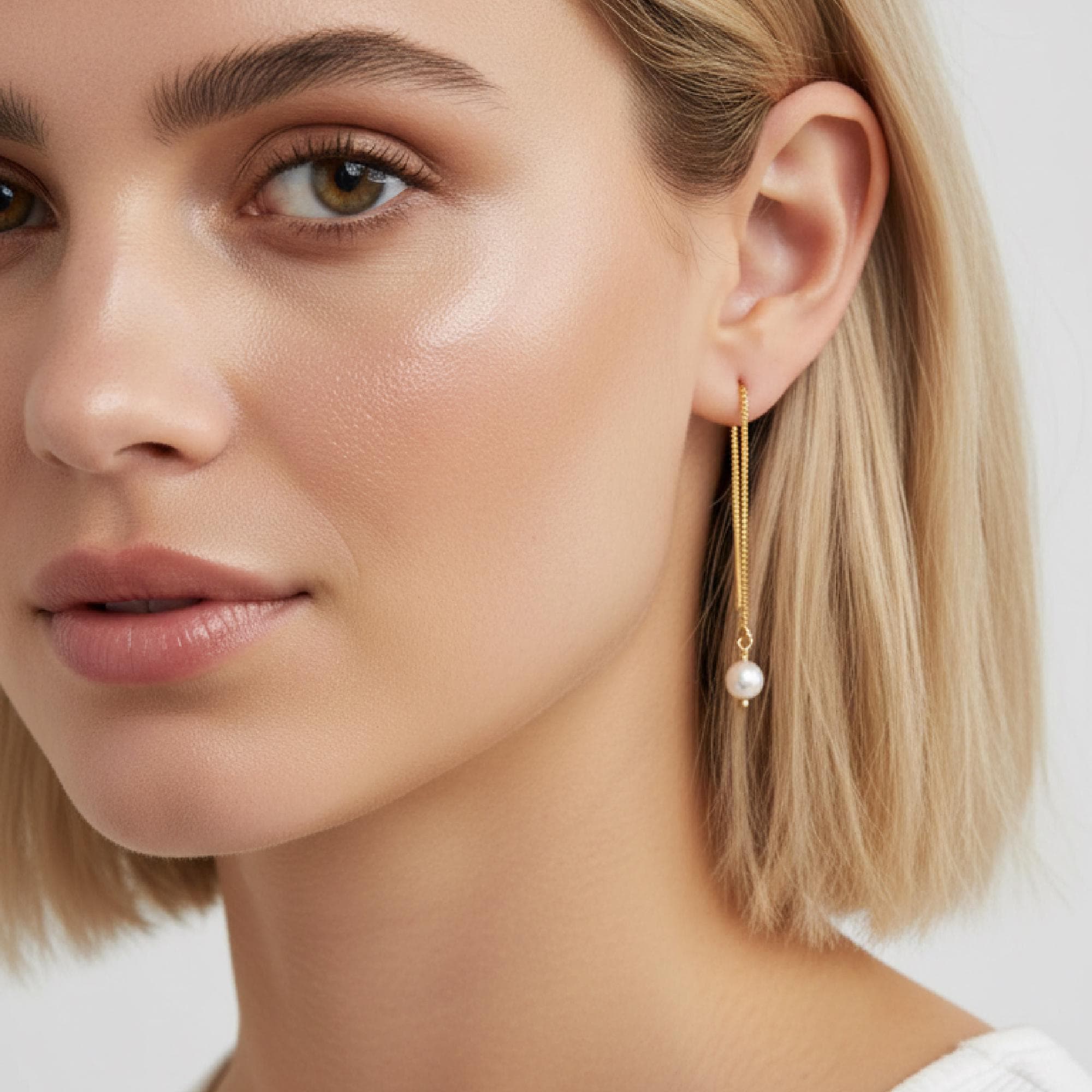 Model wearing pearl threader earrings with delicate gold chain and pearl drop, elegant minimalist bridal jewelry