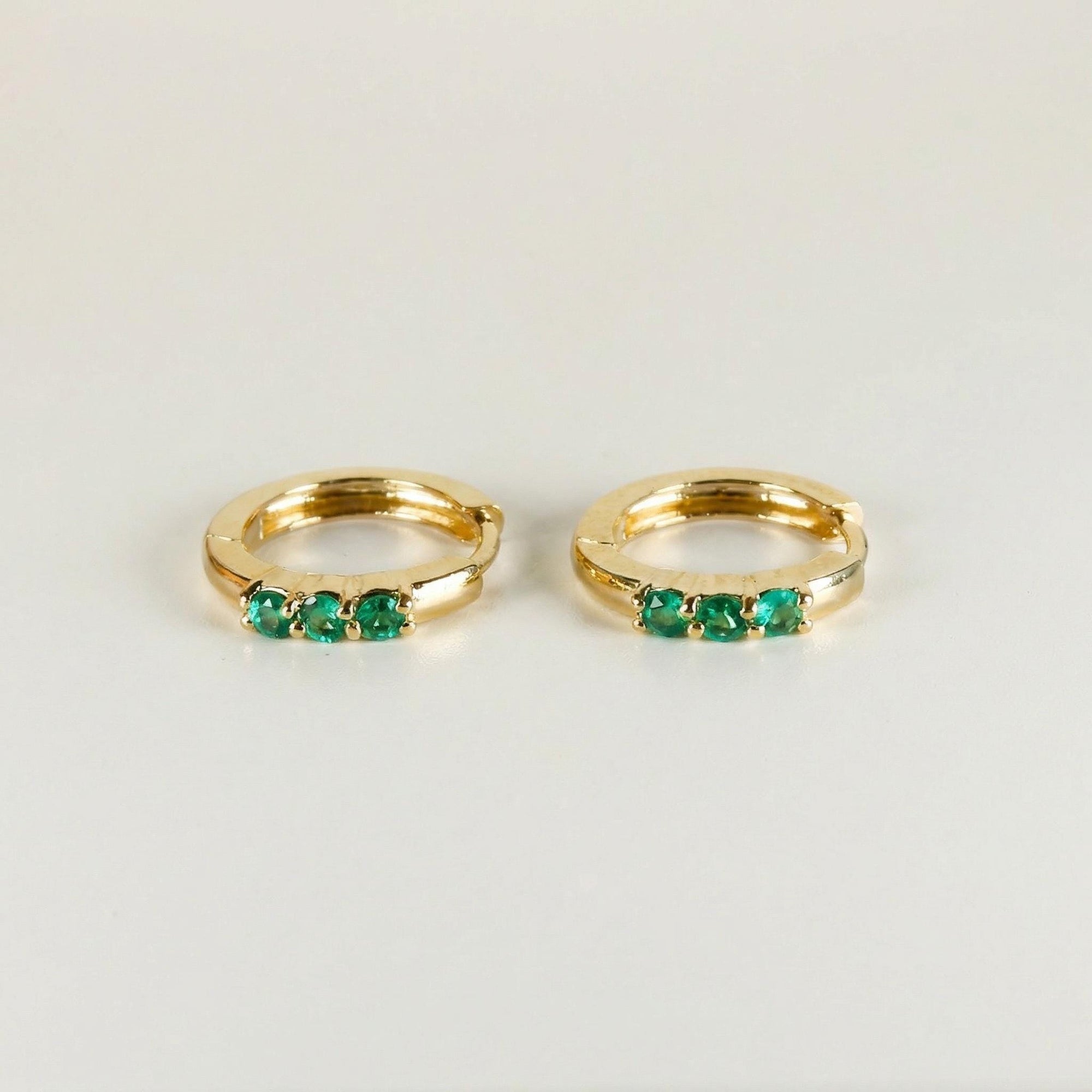 Emerald huggie hoop earrings in 14k gold with three 2mm lab grown emerald stones