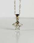14k solid gold cluster necklace featuring a center rose cut salt and pepper diamond surrounded by pear-shaped moissanites on a white background.
