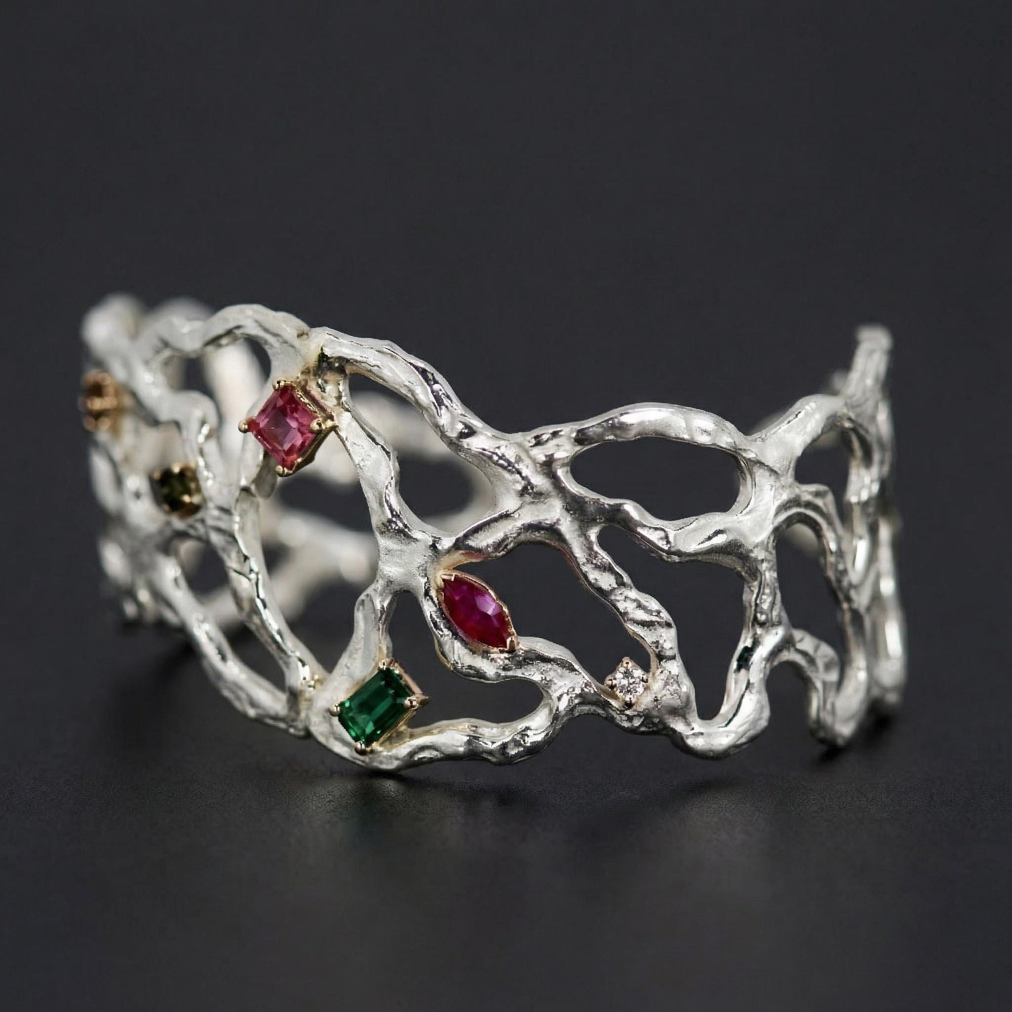 Sterling silver cuff bracelet with emerald, tourmaline, ruby, and diamond gemstones, handmade unique nature inspired jewelry.