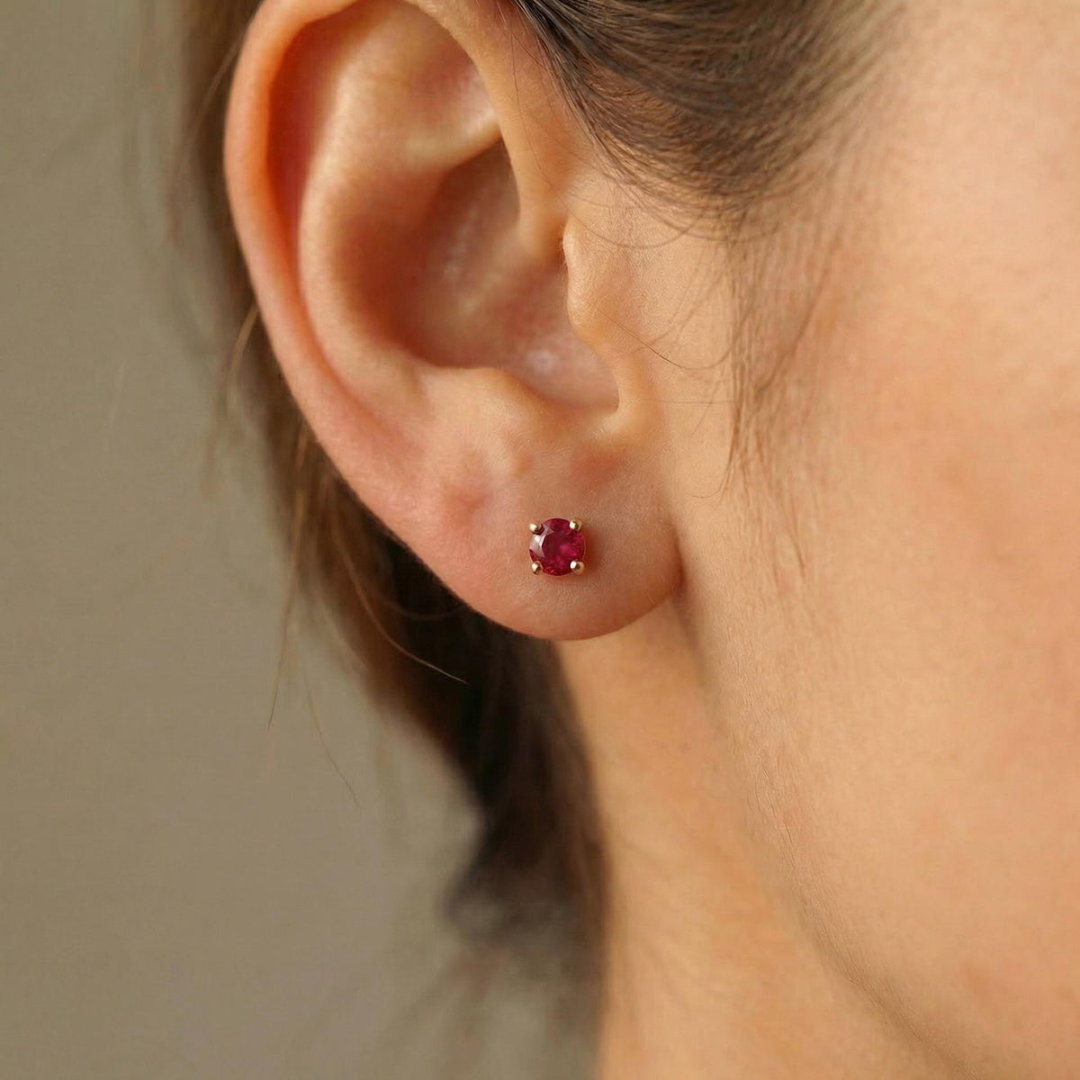 14k solid gold ruby stud earrings worn on ear, delicate natural red gemstone jewelry for everyday wear