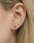Small gold filled heart stud earrings worn on ear, minimalist tiny heart earrings