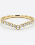 Curved diamond chevron wedding band in 14k yellow gold, V shaped contour ring with small diamonds, minimalist bridal stacking ring flat lay on neutral background