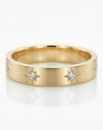 Diamond starburst eternity wedding band in 14k gold, delicate celestial diamond ring with starburst setting flat lay on neutral background