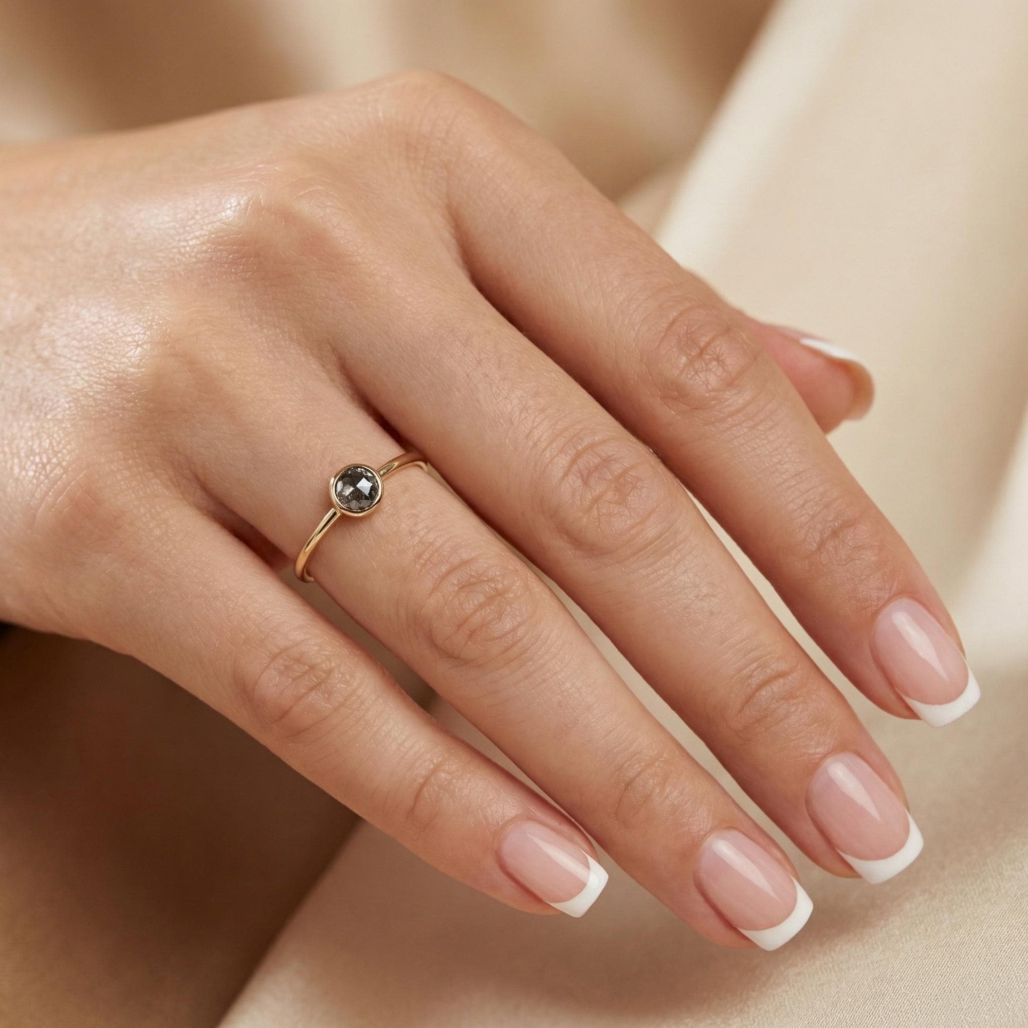 Model wearing dainty salt and pepper diamond ring in solid 14k gold, minimalist rustic stacking ring