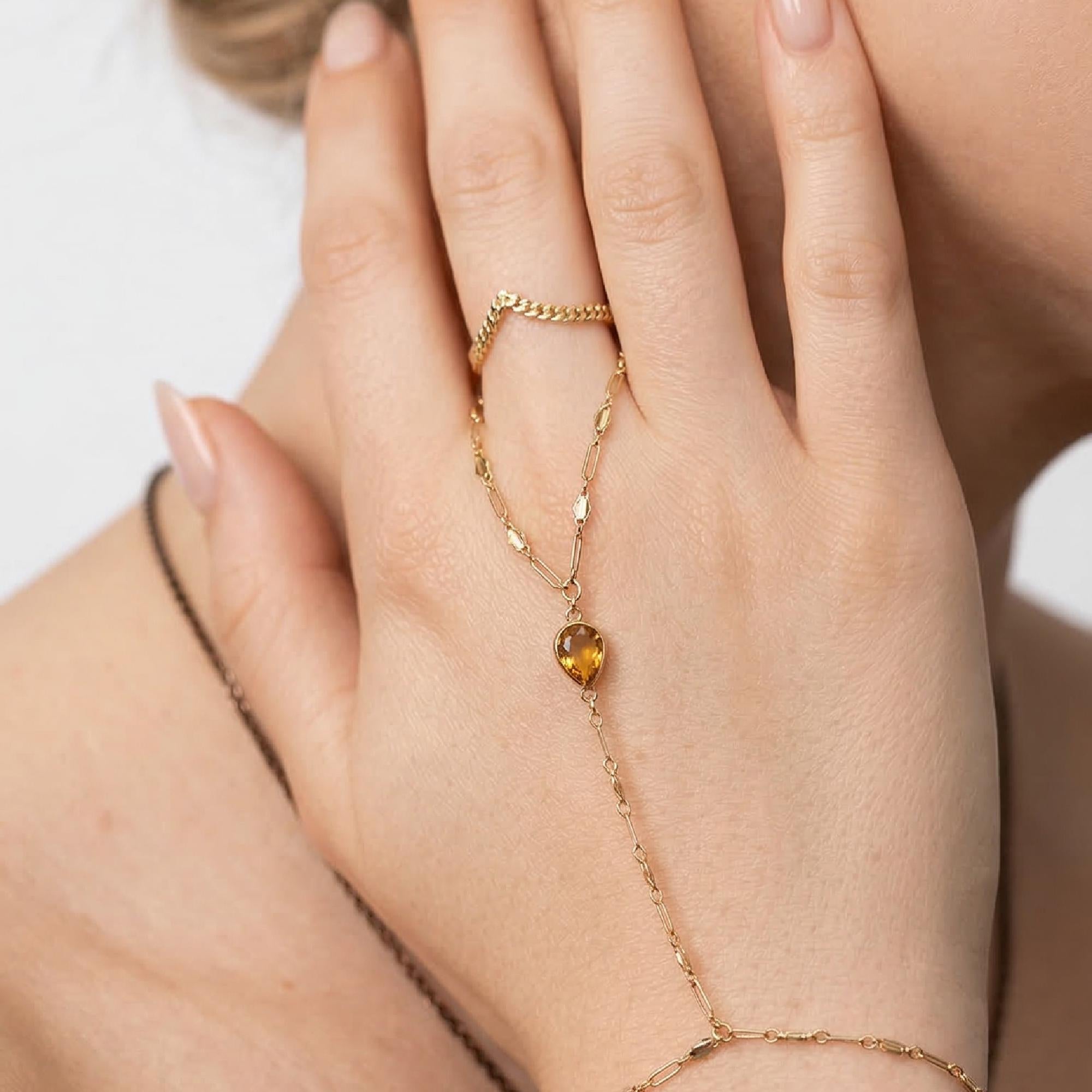 Bezel set citrine gold hand chain bracelet connected to ring, elegant boho slave bracelet model worn.