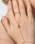 Bezel set citrine gold hand chain bracelet connected to ring, elegant boho slave bracelet model worn.
