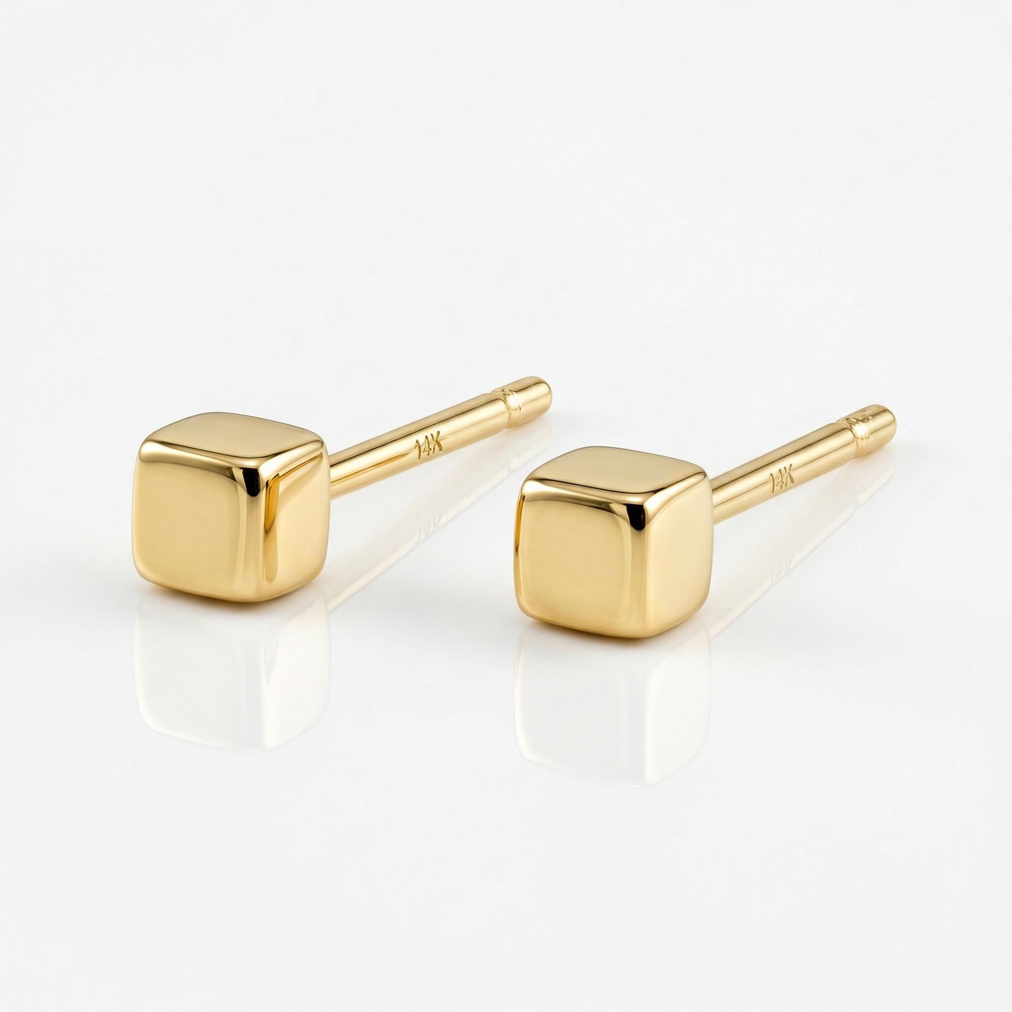 A pair of gold square stud earrings. The earrings are small and simple, with a minimalist design.
