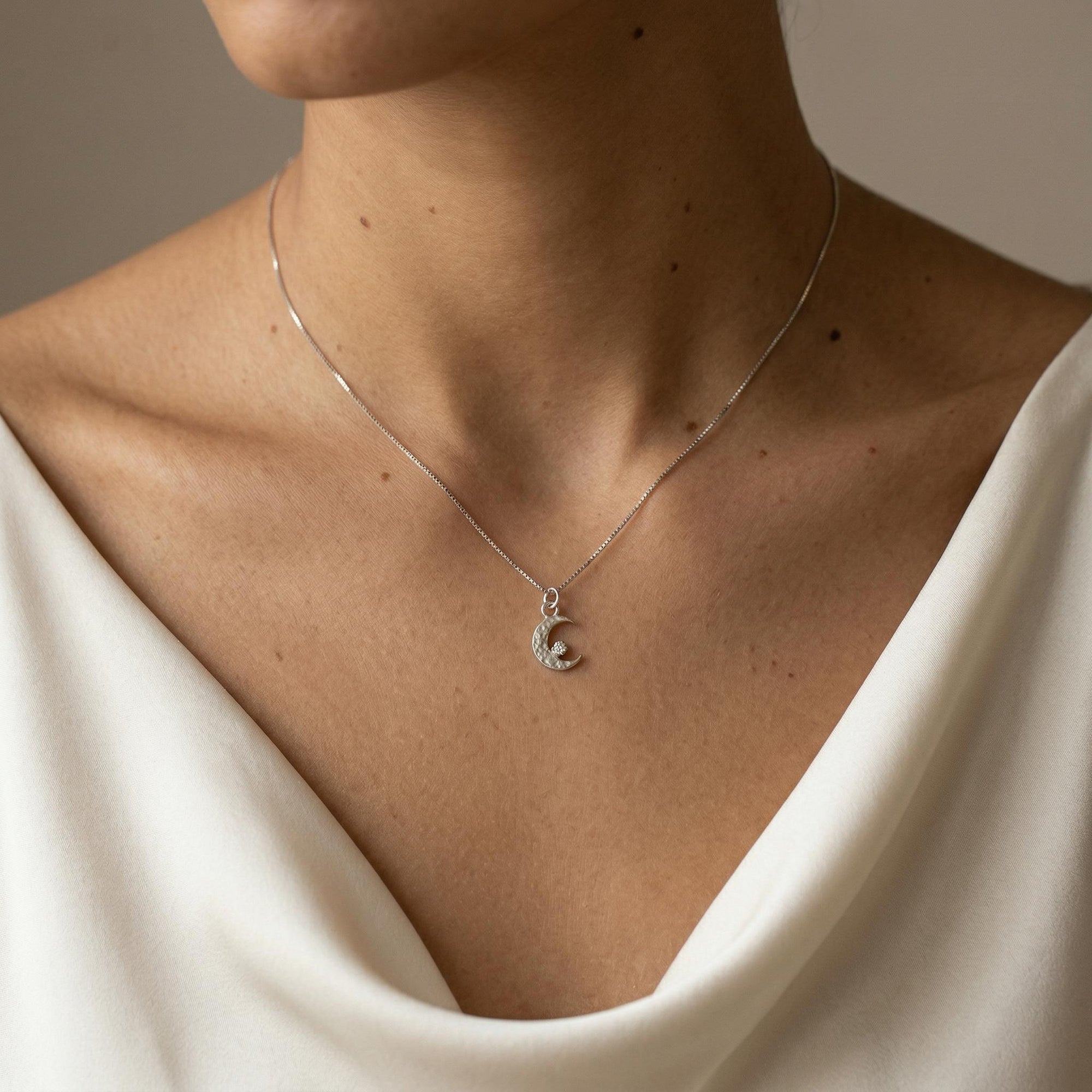 crescent moon pendant necklace worn on collarbone white gold minimal celestial jewelry