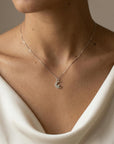 crescent moon pendant necklace worn on collarbone white gold minimal celestial jewelry